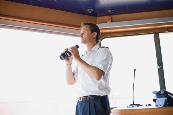 Man holding binoculars on a boat